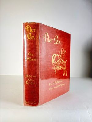 un vieux livre rouge posé sur une table blanche