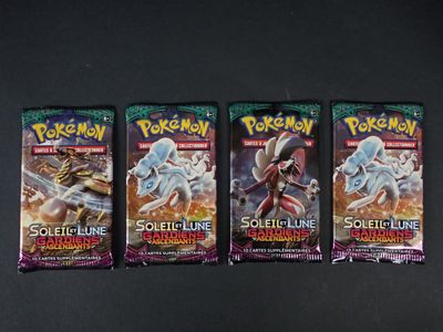 trois paquets de cartes à collectionner Pokémon posés sur une surface noire
