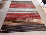 un tapis composé de bandes de différentes couleurs posé au sol