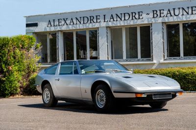 a silver sports car parked in front of a building