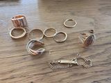 de nombreuses bagues et bracelets de toutes sortes posés sur une table en bois