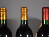 three bottles of wine sitting on a table next to each other