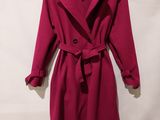 a red coat with a belt is hanging on a hanger