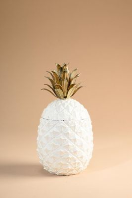 un vase blanc surmonté d'un ananas