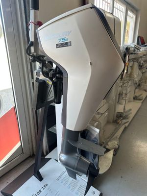 un moteur de bateau posé sur un support devant une fenêtre