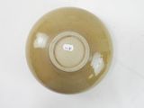 a brown bowl on a white surface with a tag on it