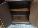 a wooden cabinet with a door open on the floor