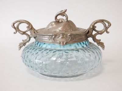 a blue glass jar with a silver lid on a table