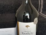 une bouteille de vin posée sur une table près d'un escalier