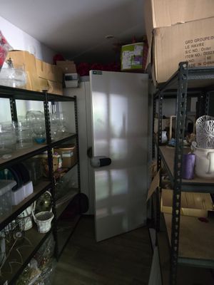 un réfrigérateur au milieu d'une pièce comportant de nombreuses étagères