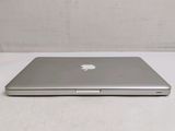 a silver apple laptop computer sitting on a white surface