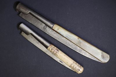 deux couteaux sont assis l'un à côté de l'autre sur une surface noire