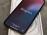 Un iPhone est posé sur une boîte, avec un chargeur dessus.