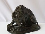 bronze statue of a lion on a rock on a white background