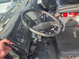 a man that is sitting in the driver ' s seat of a truck