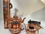three different types of copper teapots on a white table