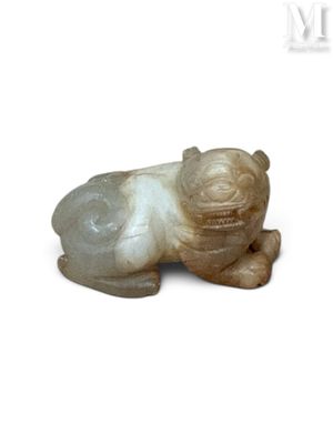 une petite figurine représentant un chien couché sur une surface blanche