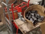 a cart with a bunch of pipes on it in a warehouse