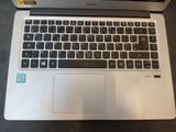 an open laptop computer sitting on top of a table next to a keyboard