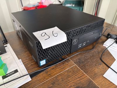 a computer on a table with a note taped to it