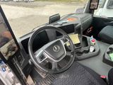 a car dashboard with a steering wheel and a monitor on the dashboard