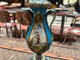 a blue and gold vase sitting on top of a wooden table