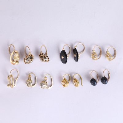 six paires de boucles d'oreilles en or et en pierre noire sur un fond blanc