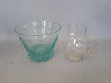 a glass pitcher and a glass bowl sitting on a table