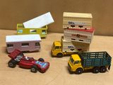 Plusieurs petites voitures et camions sont alignés sur une table