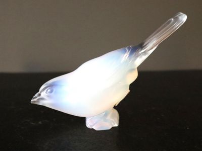 un oiseau en verre posé sur une table