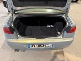 a silver car with its trunk open in a parking lot