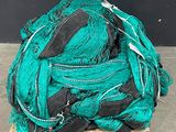 a pile of green fishing nets sitting on a pallet