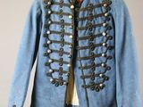 an old blue military jacket hanging on a hanger on a wall