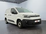 the white van is parked in a large room with a black floor