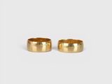 a pair of gold wedding rings on a white background