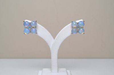 a pair of oplite and diamond earrings on a white stand
