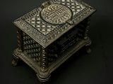 a metal box with a design on it on a black background