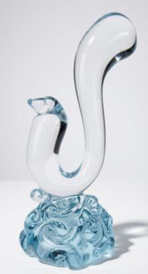 une sculpture en verre représentant un oiseau posé sur un rocher