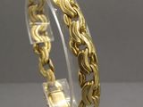 a close up of a gold bracelet on a clear stand