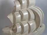 sculpture représentant un bateau blanc posé sur un socle, sur fond blanc