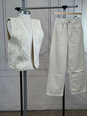 pair of white vests and pants on a mannequin stand