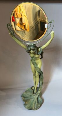 a statue of a woman holding a mirror in her hand