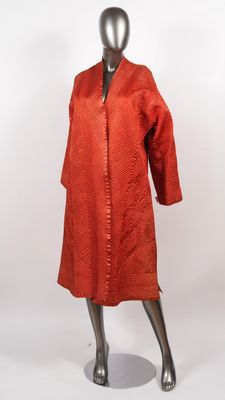 Veste longue probablement en partie en soie orange, à décor …