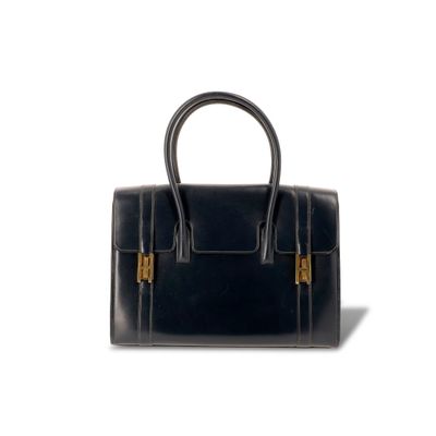 le petit sac noir est posé sur une surface blanche