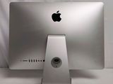 a silver apple computer sitting on top of a white table