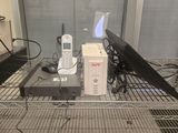 un ordinateur portable et un téléphone portable posés sur une étagère en fil métallique