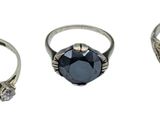 three different rings with a blue stone in them on a white surface