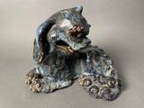 a statue of a cat sitting on top of a rock