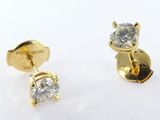 deux paires de boucles d'oreilles en diamant posées sur une surface blanche