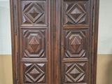 an antique wooden armoire with carved panels on top of it